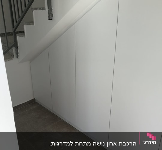 ארון עץ לבן מתחת למדרגות